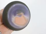 a person holding a purple candle in their hand