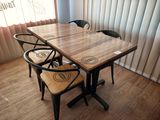 une table en bois entourée de quatre chaises dans une pièce