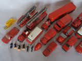 a lot of red toy trucks that are on a white surface