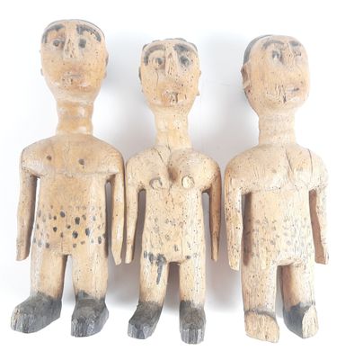 three wooden figurines of three men standing next to each other on a white surface