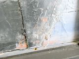 a crack in the side of a window that has been painted