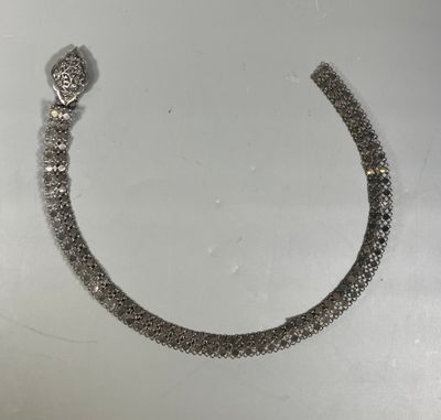 a close up of a silver bracelet with a snake on it