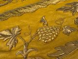 a close up of a bed with a yellow comforter on it
