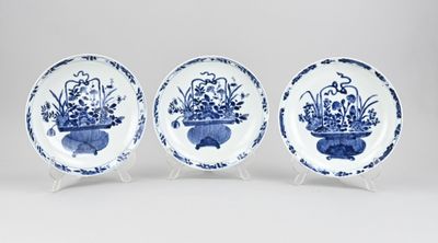 trois assiettes bleues et blanches ornées de fleurs dans des vases