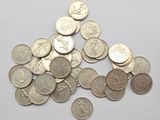 a pile of silver coins on a white surface