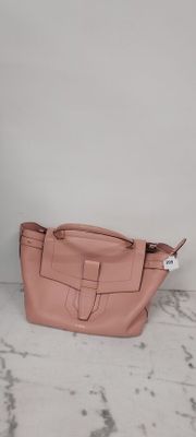 un sac à main en cuir rose posé sur une surface en marbre, près d'un mur blanc