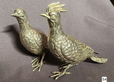 two metal birds that are sitting on a table