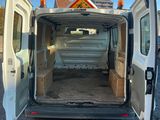 une camionnette blanche dont les portes sont ouvertes, garée sur un parking