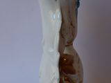 a small white vase with a gold decoration on it