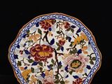 a plate with a flower design on it next to a plate with a flower design on it