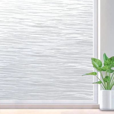 a white vase with a plant sitting on a table next to a window