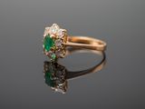 a close up of a gold ring with a green and white stone