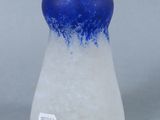 a glass vase with a blue top sitting on a table