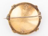 an image of a gold broochle with a woman ' s face on it