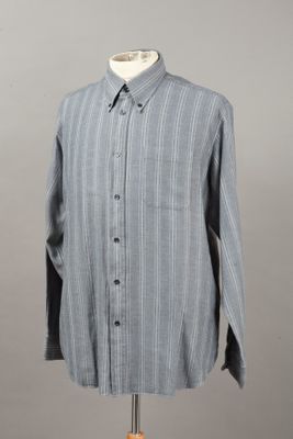 the shirt is on a mannequin stand with a gray background