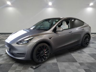 Le SUV Tesla argenté est garé dans une grande pièce.