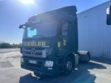 un camion vert garé devant un immeuble