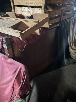 un homme assis sur une chaise à côté d'un tas de bois