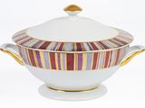 a white bowl with a gold rim and a striped lid