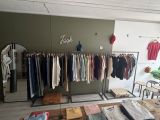 a picture of a clothing store with lots of clothes on racks