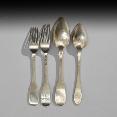 trois cuillères et une fourchette sont posées sur une table