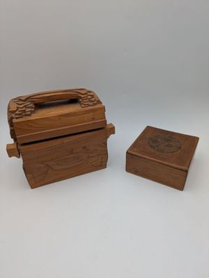 two small wooden boxes with lids and handles on a white surface