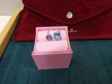 a pink box with a ring inside of it on a blue carpet