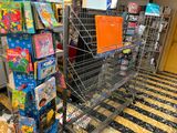 a shopping cart in the middle of a store filled with children ' s toys
