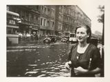 black and white photograph of a woman standing in the middle of a street