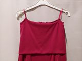 pink dress hanging on a hanger in front of a white wall