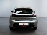 the rear end of a silver car in a room with a white wall