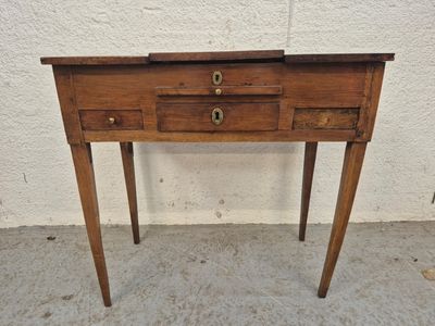 une vieille table en bois surmontée de deux tiroirs