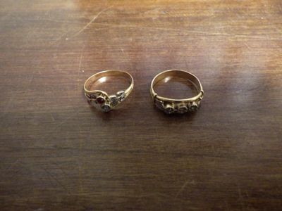 une paire de bagues en or ornées de grenats, posées sur une table en bois