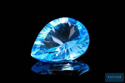 a close up of a blue diamond on a black surface