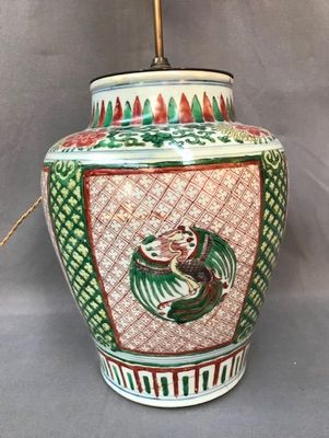 un vase vert et rouge orné d'un oiseau
