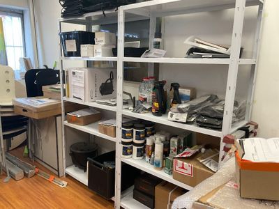 une pièce équipée d'un bureau, d'étagères, d'une chaise et d'une imprimante