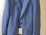 the blue suit is hanging on a hanger on the wall