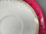 a pink and gold plate with a gold rim