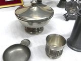 a lot of silver items on a table with a picture frame