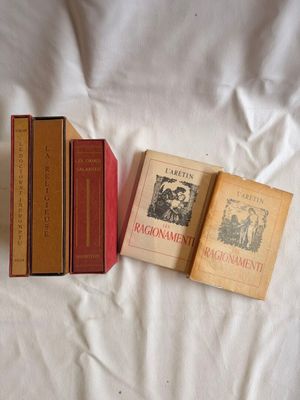 trois livres posés les uns à côté des autres sur un lit