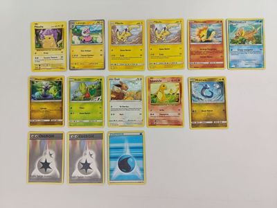 de nombreuses cartes Pokémon disposées sur une surface blanche