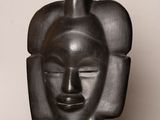 sculpture of a black mask with a pointed nose and a pointed nose