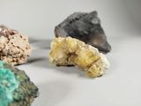 several different colored rocks and minerals are arranged on a white surface