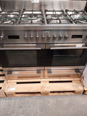 several stainless steel stoves are stacked on pallets in a warehouse