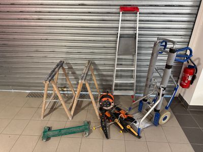 many tools that are sitting on the floor in front of a garage door