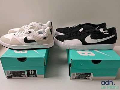 Trois paires de chaussures Nike sont posées sur une table, à côté d'une boîte.