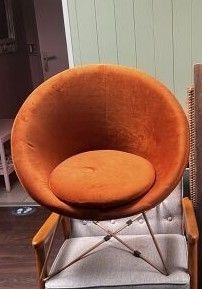 une chaise orange et une chaise marron dans un salon