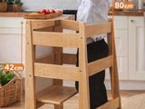 a young boy that is standing in a high chair