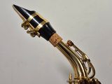 a close up of a saxophone with a black and gold neck