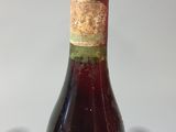 a bottle of wine sitting on a table next to a pair of scissors